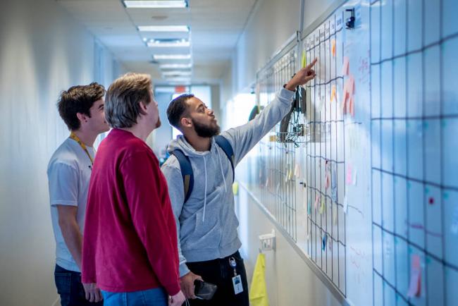 People pointing at whiteboard